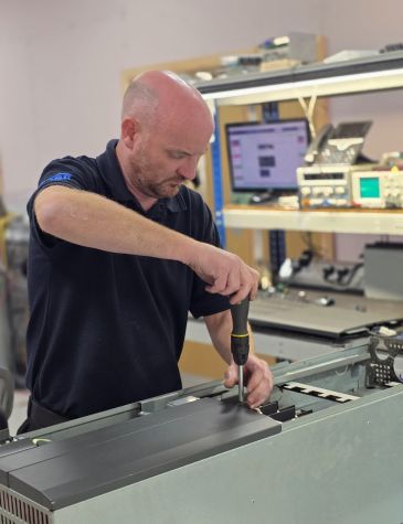 Engineer Dav working on variable speed drive Repairs at Neutronic Technologies workshop, testing and servicing an industrial drive unit on a workbench.
