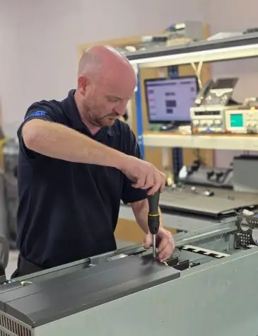 Engineer Dav working on variable speed drive Repairs at Neutronic Technologies workshop, testing and servicing an industrial drive unit on a workbench.