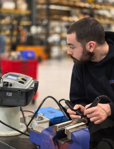 DC Motor Rewind & Repair Services carried out by Neutronic Technologies engineer performing precision electrical testing on a DC motor component.