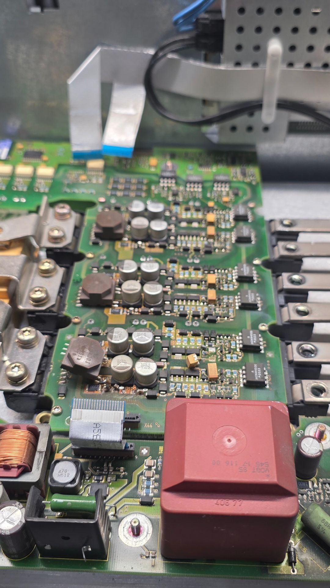 This is a close-up of an electronic circuit board that is undergoing power supply repairs, showing detailed components and internal hardware.