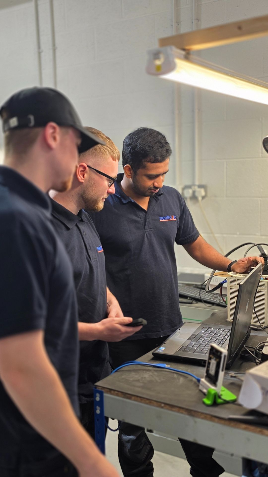 Engineers performing servo drive repairs at a Neutronic Technologies workstation, ensuring optimal functionality and precision.