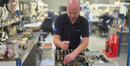 A neutronic engineer repairing industrial drive and inverter system for distribution centre automation equipment in a professional repair facility.