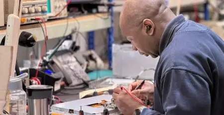 A Neutronic Engineer working on PLC and HMI control system repairs for warehouse automation and distribution centre control equipment.