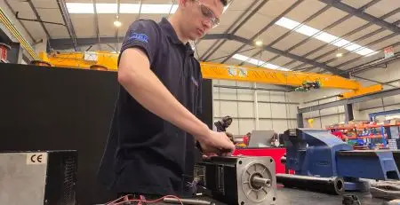 A Neutronic Engineer repairing servo motor and precision automation system in industrial workshop for distribution centre automation repairs.