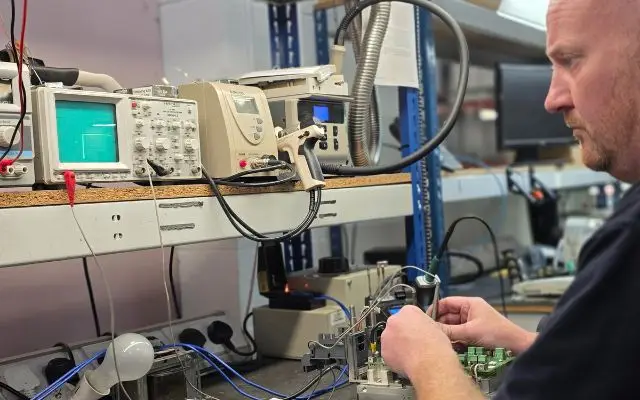 Industrial power supply repair engineer diagnosing and testing electronic control equipment at Neutronic Technologies UK